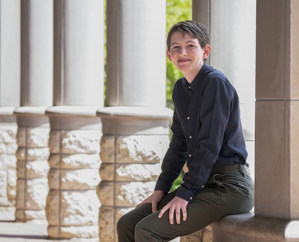 Flynn sits in front of stone columns.