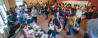 several students lined up to speak to someone at a career fair event