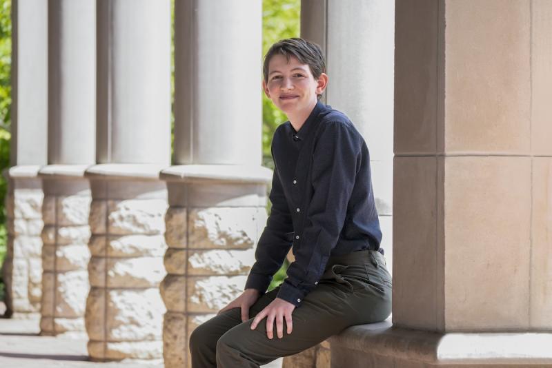 Flynn sits in front of stone columns.