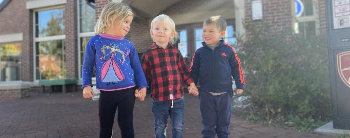 Children holding hands in front of FELC buidling