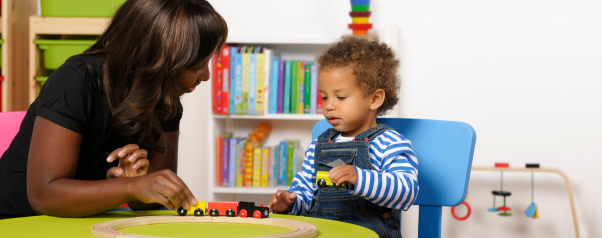 A teacher and student count with train cars