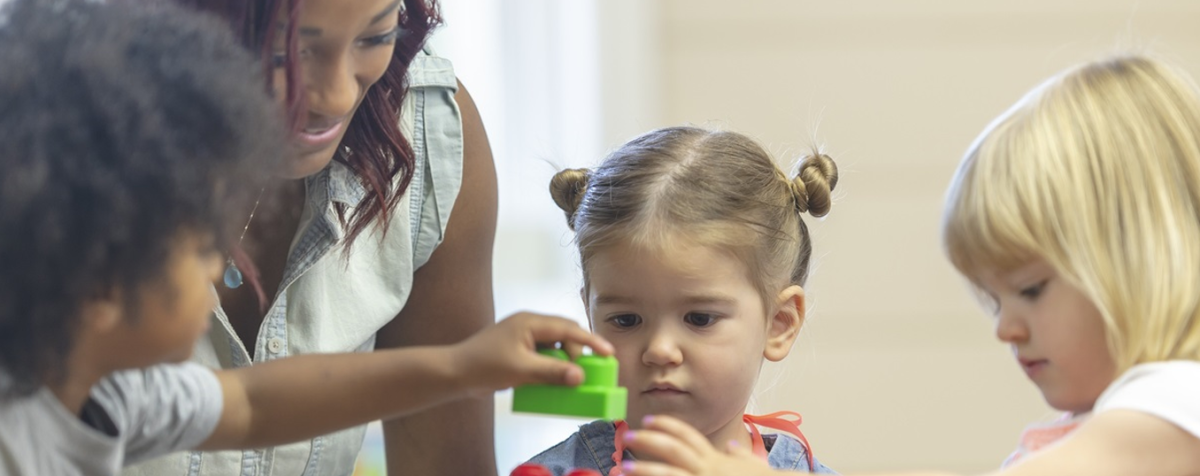 teacher and preschoolers playing with blocks